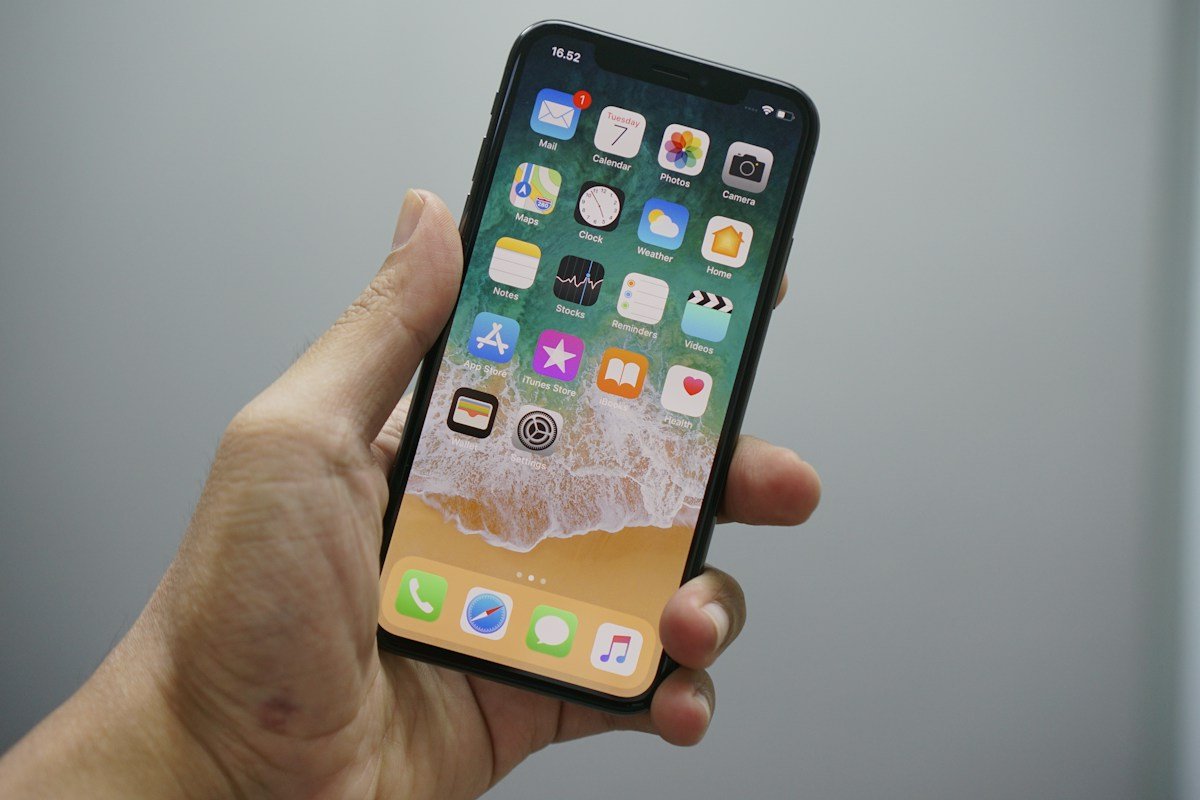 Un iPhone sostenido en una mano; fotografía ilustrativa de referencia